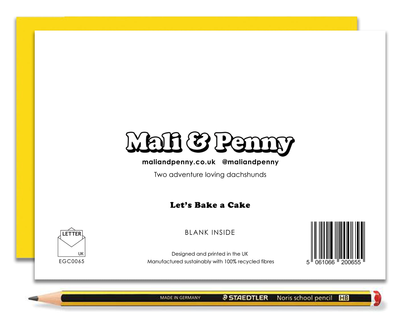 The back of a fun dachshund birthday card featuring dachshunds, Mali & Penny decorating a massive birthday cake.  Coupled with a bright, cheerful yellow envelope, with a pencil to show the scale of the card.